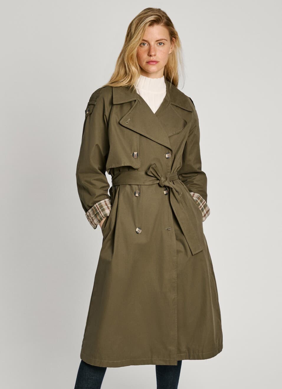A woman in a long olive belted trench coat