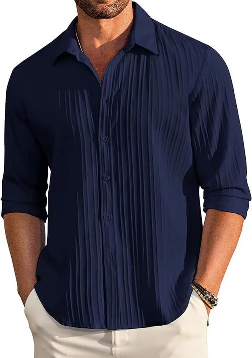 Navy long-sleeve textured shirt with sleeves rolled, over cream trousers
