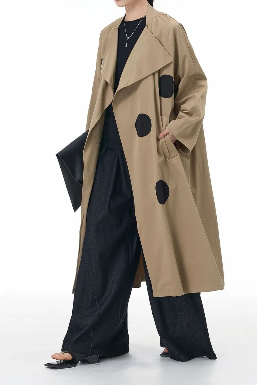 Sand long open-front trench coat with dot detail, worn with wide trousers