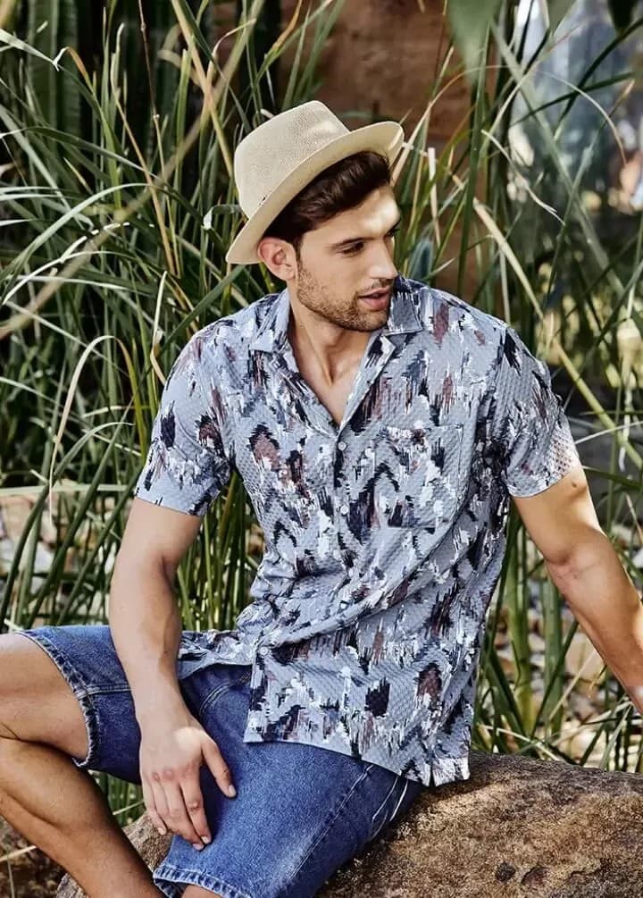 Slate blue abstract-print camp collar shirt on a seated model